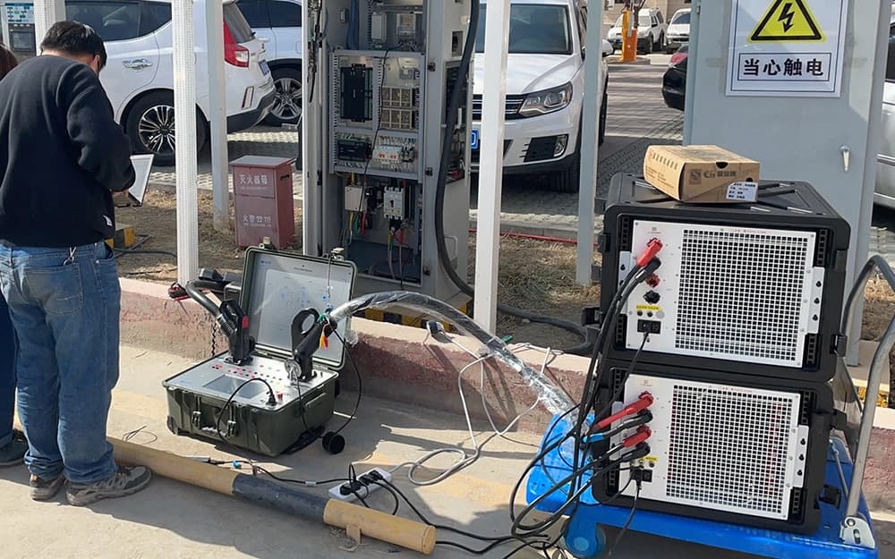 Portable charging test instrument and stacked load units beside an open charging cabinet
