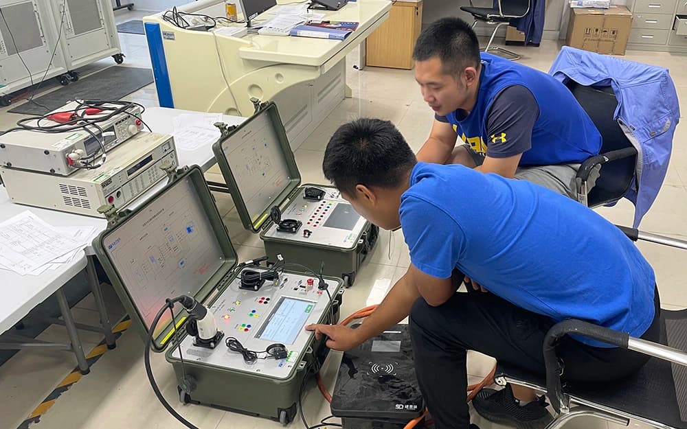 Two technicians operating portable charging test instruments in a laboratory