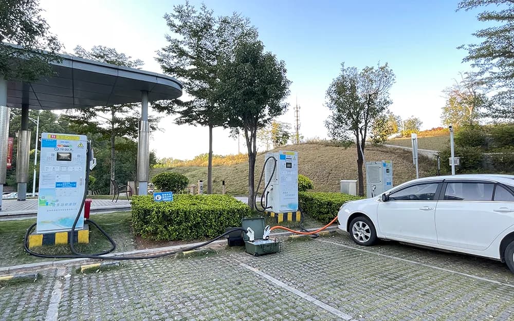 Portable charging test instrument connected between a white electric vehicle and a charging station