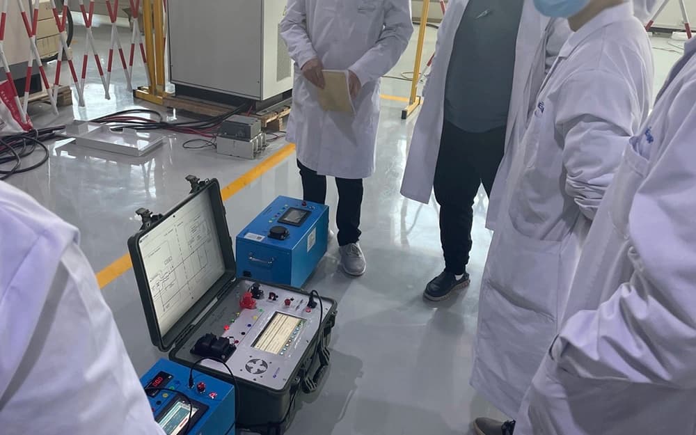 Technicians examining a portable charging test instrument in a laboratory