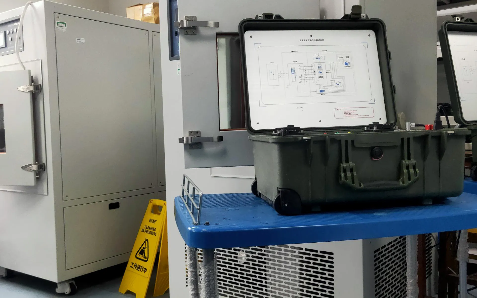 Portable EV charging test instrument beside laboratory test cabinets
