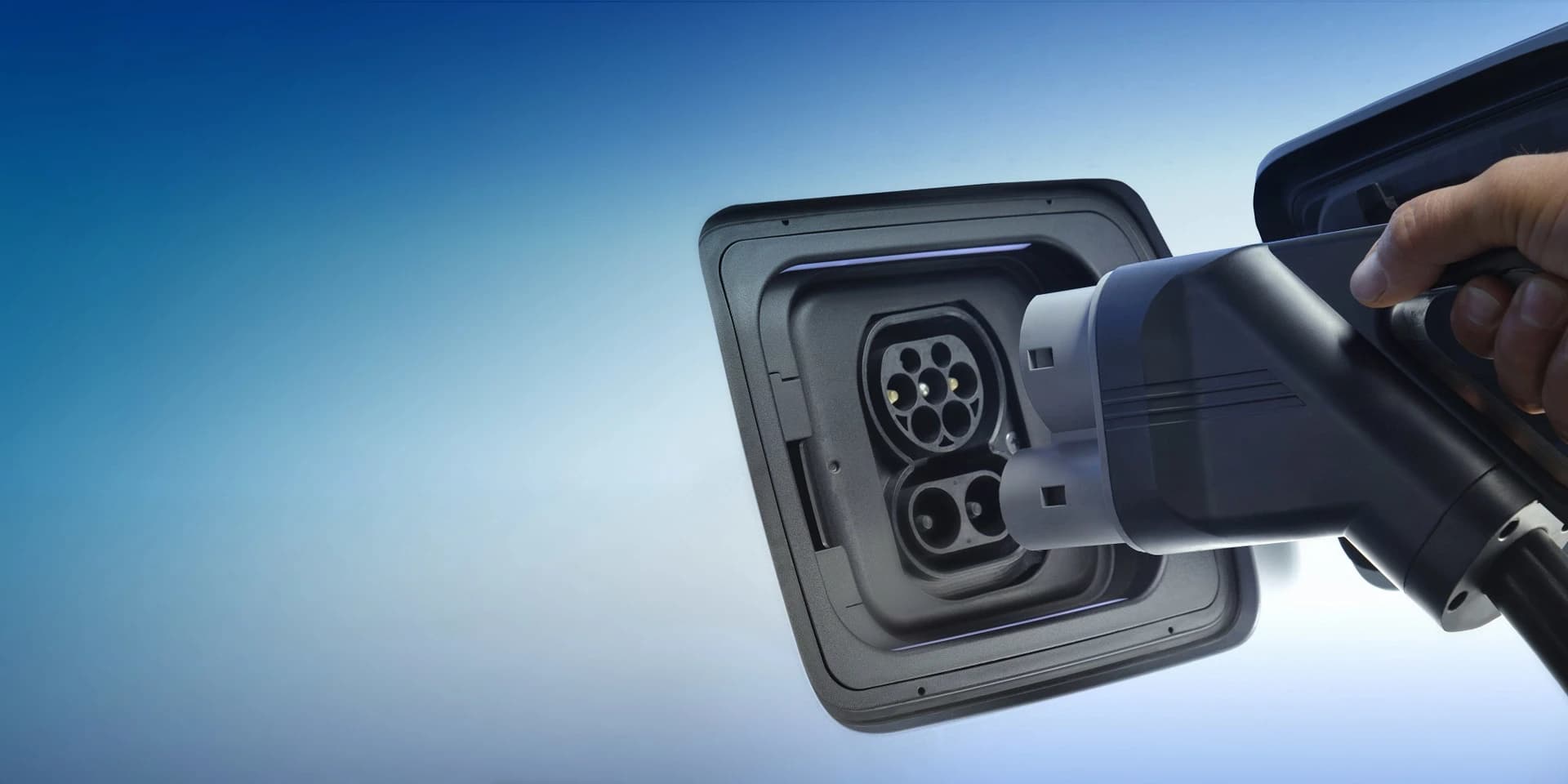 A charging connector held beside an electric vehicle